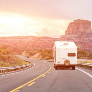 Road trip by motorhome car with background of mountains and bright orange light